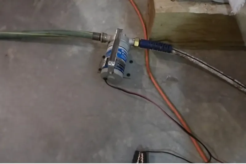 Sump pump and discharge pipe installed in a utility area for A rural Mayer property in Mayer, AZ