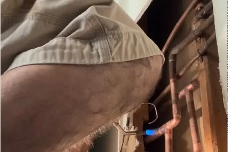 Technician checking a hidden plumbing leak in a wall or crawl space for Pool Leak Detection & Repair