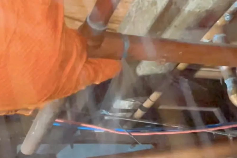 Technician checking a hidden plumbing leak in a wall or crawl space for A Tri-Cities well system